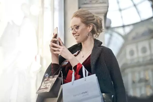 Woman looking at her phone while shopping
